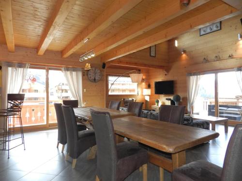 une salle à manger avec une table et des chaises en bois dans l'établissement Penthouse : fantastique duplex au dernier étage d'un chalet, à Châtel