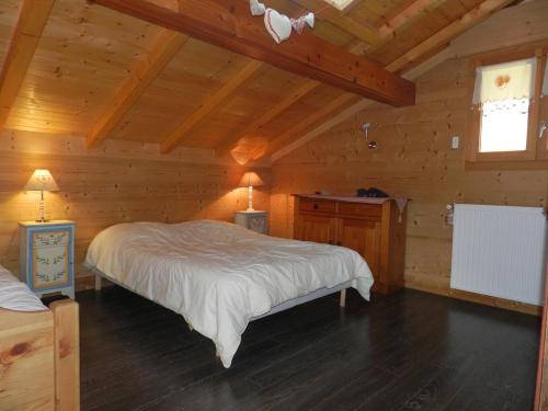 une chambre avec un lit dans une cabane en bois dans l'établissement Penthouse : fantastique duplex au dernier étage d'un chalet, à Châtel
