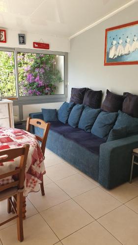 - un canapé bleu dans le salon dans l'établissement appartement rdc jardin, au Grau-du-Roi