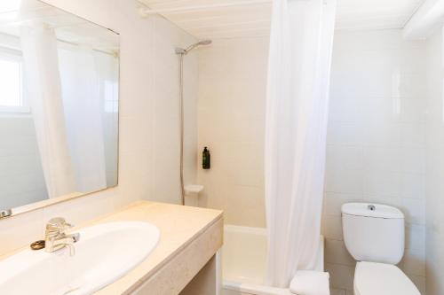 a bathroom with a sink and a toilet and a mirror at O7 Colombo in S'Illot
