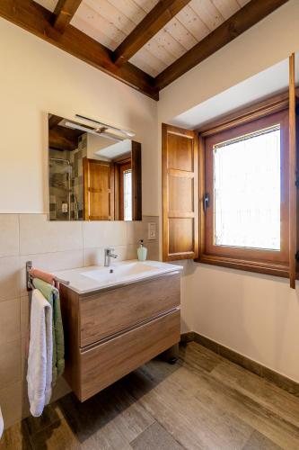 a bathroom with a sink and a window at Lagar de Beuvas in Camanzo