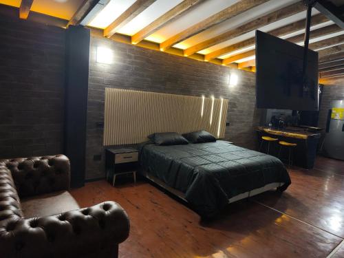 1 dormitorio con 1 cama y silla de cuero en Cabaña Celeste, en Rionegro