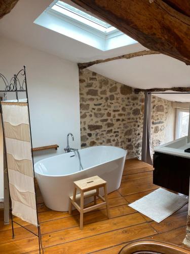 une salle de bain avec une baignoire blanche et un lavabo dans l'établissement Old wine storehouse and its outbuilding, à Gabian