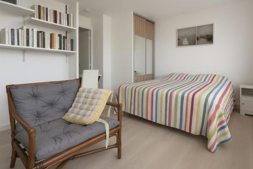 une chambre avec un lit, un canapé et une chaise dans l'établissement Luminous apartment with sea view in La Ciotat, à La Ciotat