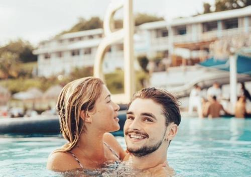 a man and a woman in a swimming pool at 412 The Diamond Swing in Le Diamant