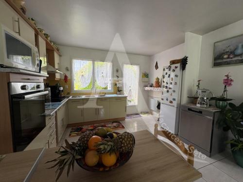 - une cuisine avec un bol de fruits sur une table dans l'établissement Maison 6 personnes, salon climatise, wifi et stationnement, à Sète