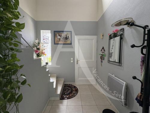un escalier dans une maison aux murs gris dans l'établissement Maison 6 personnes, salon climatise, wifi et stationnement, à Sète