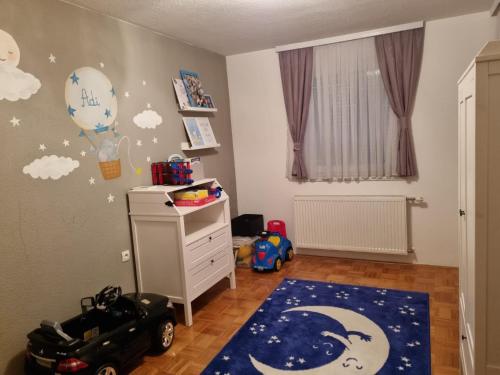 a childs bedroom with a moon and balloons on the wall at VK Centar in Velika Kladuša