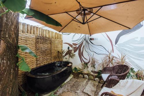 a bathroom with a bath tub and an umbrella at Smart Hotel Reserva Ilhabela in Ilhabela