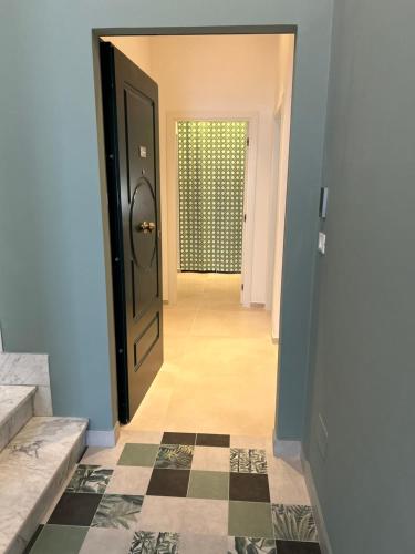 a hallway with a black door and a tile floor at La Foresteria Termoli in Termoli