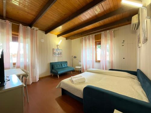 a bedroom with a bed and a blue chair at Oasi Venus Perugia e Assisi in Ponte San Giovanni