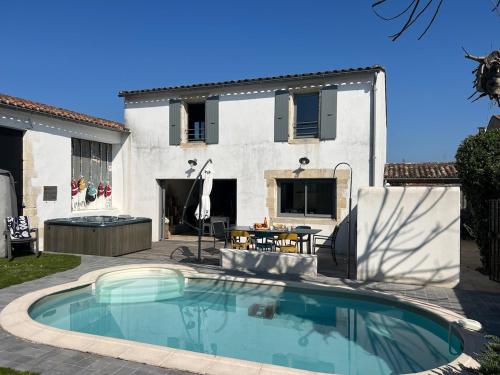 une piscine devant une maison dans l'établissement Le Clos des Figuiers villa pool and jacuzzi, à La Flotte