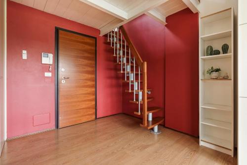a hallway with a red wall and a wooden door at view of the Arno Perla sull'Arno IX in Florence