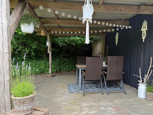 a patio with a table and chairs under a pergola at FeWo Hygge Hennstedt in Hennstedt