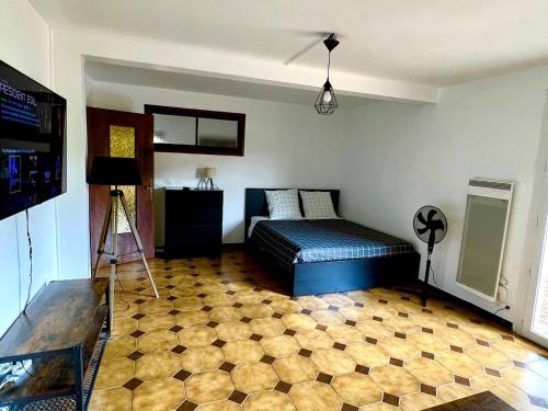 une chambre avec un lit et un sol carrelé dans l'établissement Magnifique appartement dans villa rénovée de 45m2, à Pérols