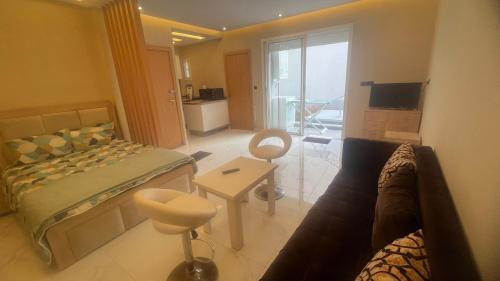 a bedroom with a bed and a living room with a couch at Cozy studio with terrace Hassan in Rabat