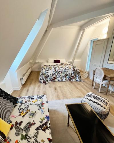 - une chambre mansardée avec 2 lits et une table dans l'établissement Château de Foussal, à Issigeac