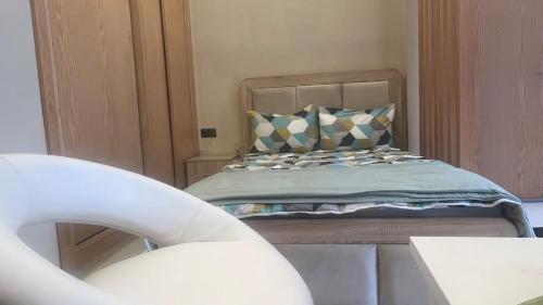 a bedroom with a bed and a chair at Cozy studio with terrace Hassan in Rabat