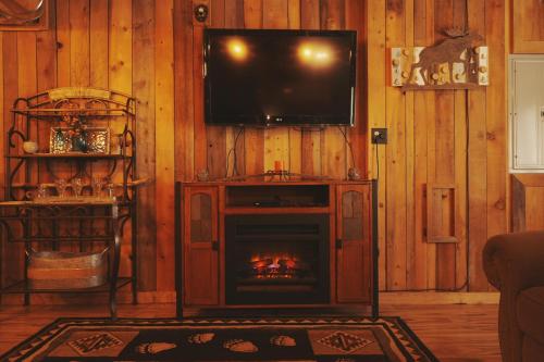 a living room with a fireplace and a television at Cascade Sunset House - Crater Lake Adventures! in Eagle Point