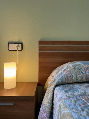a bedroom with a bed and a lamp on a night stand at Casa Herrero Valderrobres in Valderrobres