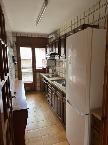 a kitchen with a white refrigerator and a sink at Casa Herrero Valderrobres in Valderrobres