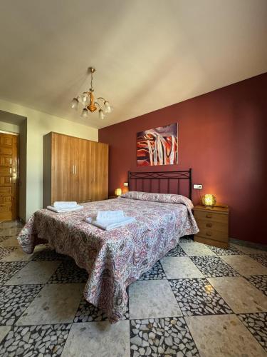 a bedroom with a large bed and red walls at Casa Herrero Valderrobres in Valderrobres