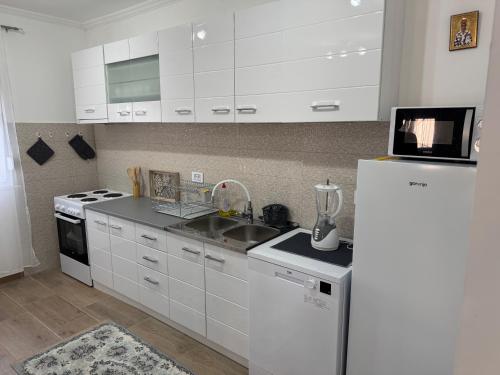 a kitchen with white cabinets and a white refrigerator at Lukic Guest house in Ulcinj