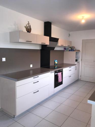 une cuisine avec des armoires blanches et un comptoir noir dans l'établissement Chambre double lit King size, à La Celle-sous-Gouzon