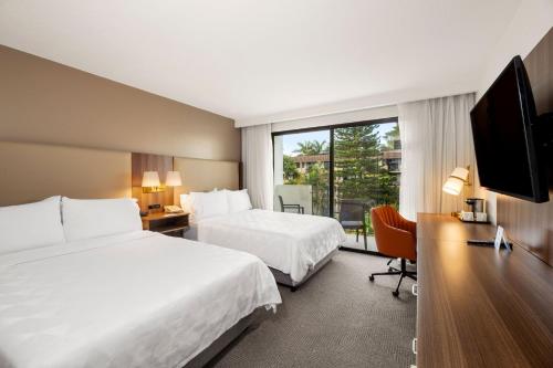 a hotel room with two beds and a television at Holiday Inn San Jose La Sabana by IHG in San José