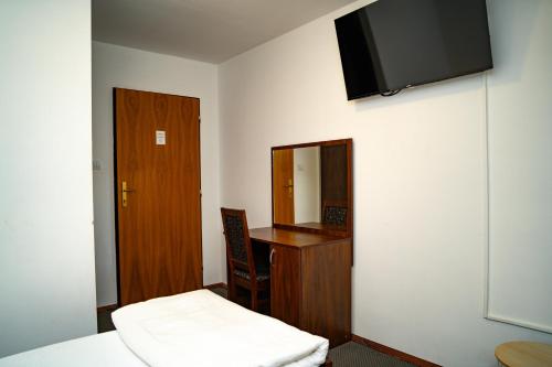 a room with a bed and a desk and a mirror at Penzión Zvala in Pichne