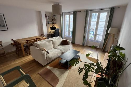 un salon avec un canapé blanc et une table dans l'établissement T3 bright and quiet 2 steps Montmartre Batignolles, à Paris