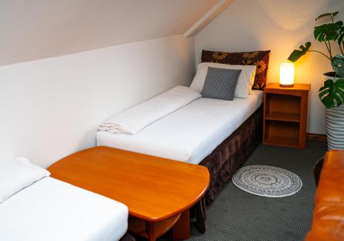 a small room with two beds and a table at Penzión Zvala in Pichne