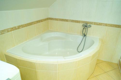 a bath tub with a shower in a bathroom at Penzión Zvala in Pichne