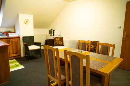 a living room with a dining room table and chairs at Penzión Zvala in Pichne