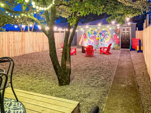 a park with red chairs and a tree and lights at The Lucky Horseshoe in Louisville