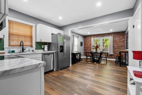 a kitchen with stainless steel appliances and a dining room at The Lucky Horseshoe 4BR Derby Side Retreat in Louisville