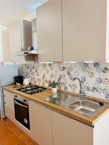 a kitchen with white cabinets and a sink at Camillas Loft in Villasimius