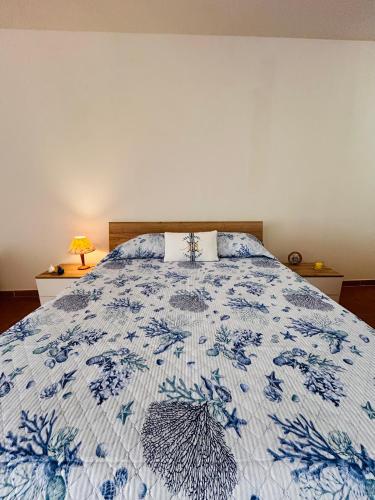 a bedroom with a bed with a blue and white quilt at Camillas Loft in Villasimius