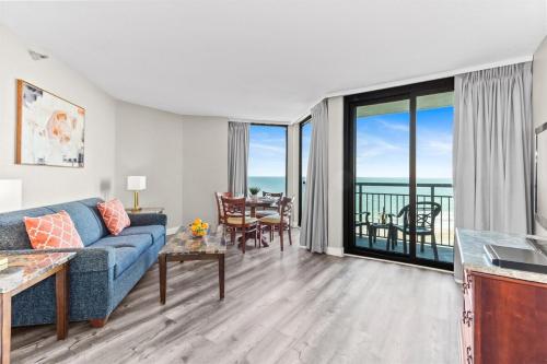 a living room with a couch and a table with a view at Grand Oceanfront 1Br Suite, Dogs OK! 710 in Myrtle Beach