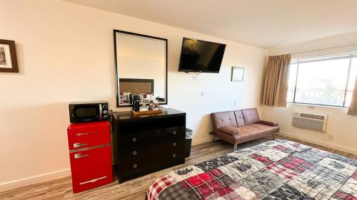 a bedroom with a bed and a dresser and a television at Riverwood Resort on the Gunnison in Delta