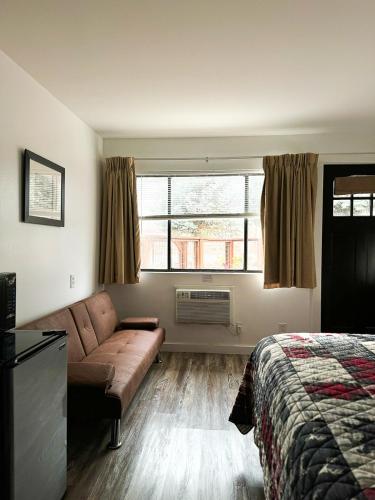 a bedroom with a couch and a bed and a window at Riverwood Resort on the Gunnison in Delta