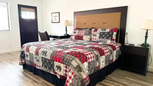 a bedroom with a bed with a red and black blanket at Riverwood Resort on the Gunnison in Delta