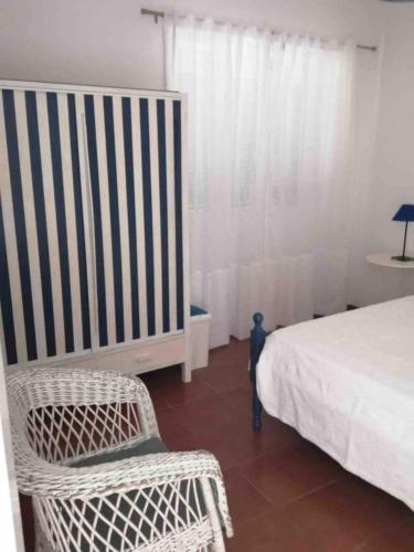 a bedroom with a bed and a chair and a window at GuestReady - Cheerful Ponta Delgada townhouse in Ponta Delgada