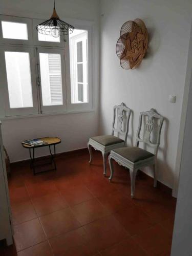 a living room with two chairs and a table at GuestReady - Cheerful Ponta Delgada townhouse in Ponta Delgada