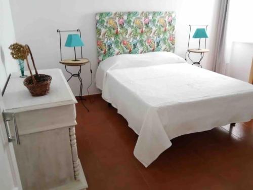 a bedroom with a large white bed and two lamps at GuestReady - Cheerful Ponta Delgada townhouse in Ponta Delgada