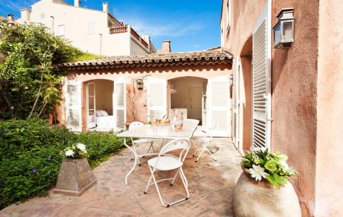 an outdoor patio with a table and chairs at Maison Jolie in Saint-Tropez