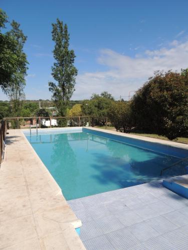 a large swimming pool with blue water at Sampa Pacha - Cabaña 3 in Villa Parque Siquiman