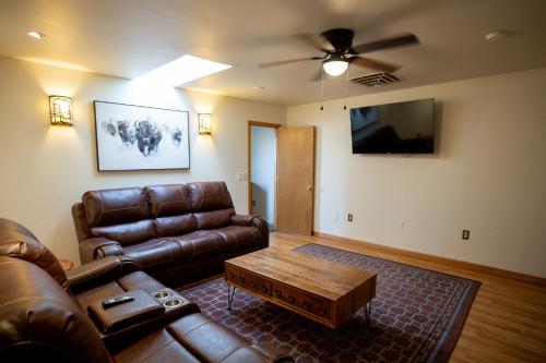 a living room with a leather couch and a coffee table at Riverwood Resort on the Gunnison in Delta