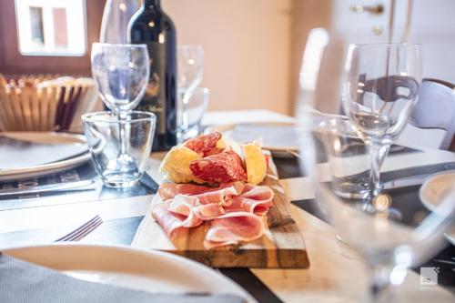 a table with a cutting board with meat and wine glasses at Tenuta Il Burchio in Incisa in Valdarno