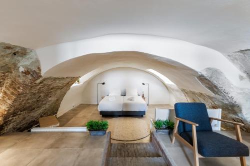 a bedroom with a bed and two chairs at Unique underground hotel in Utrecht city center in Utrecht